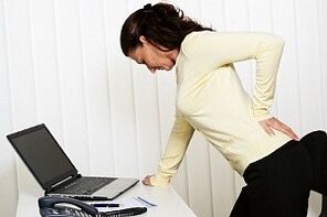 a woman has back pain in the lower back